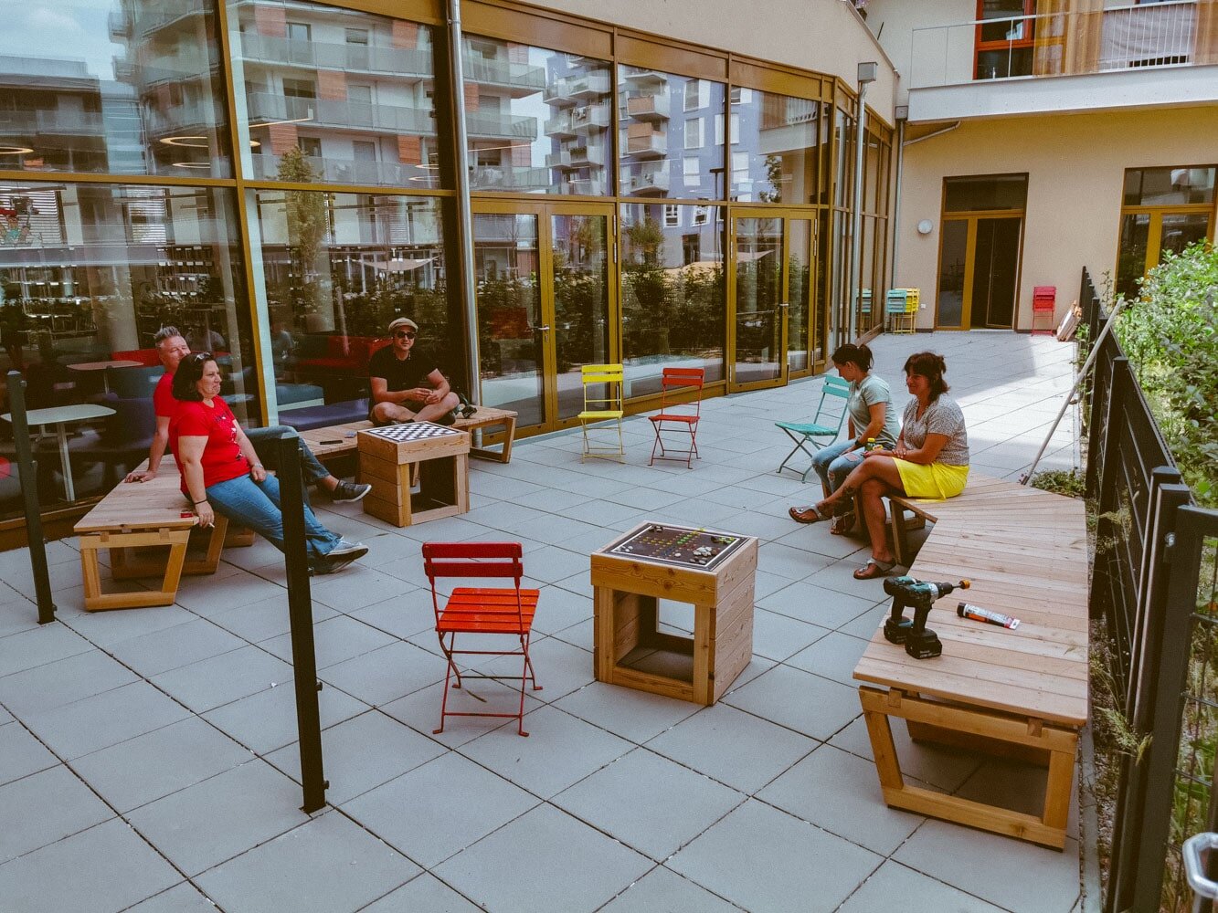Menschen sitzten im Sommer bei warmen Wetter draußen beisammen.