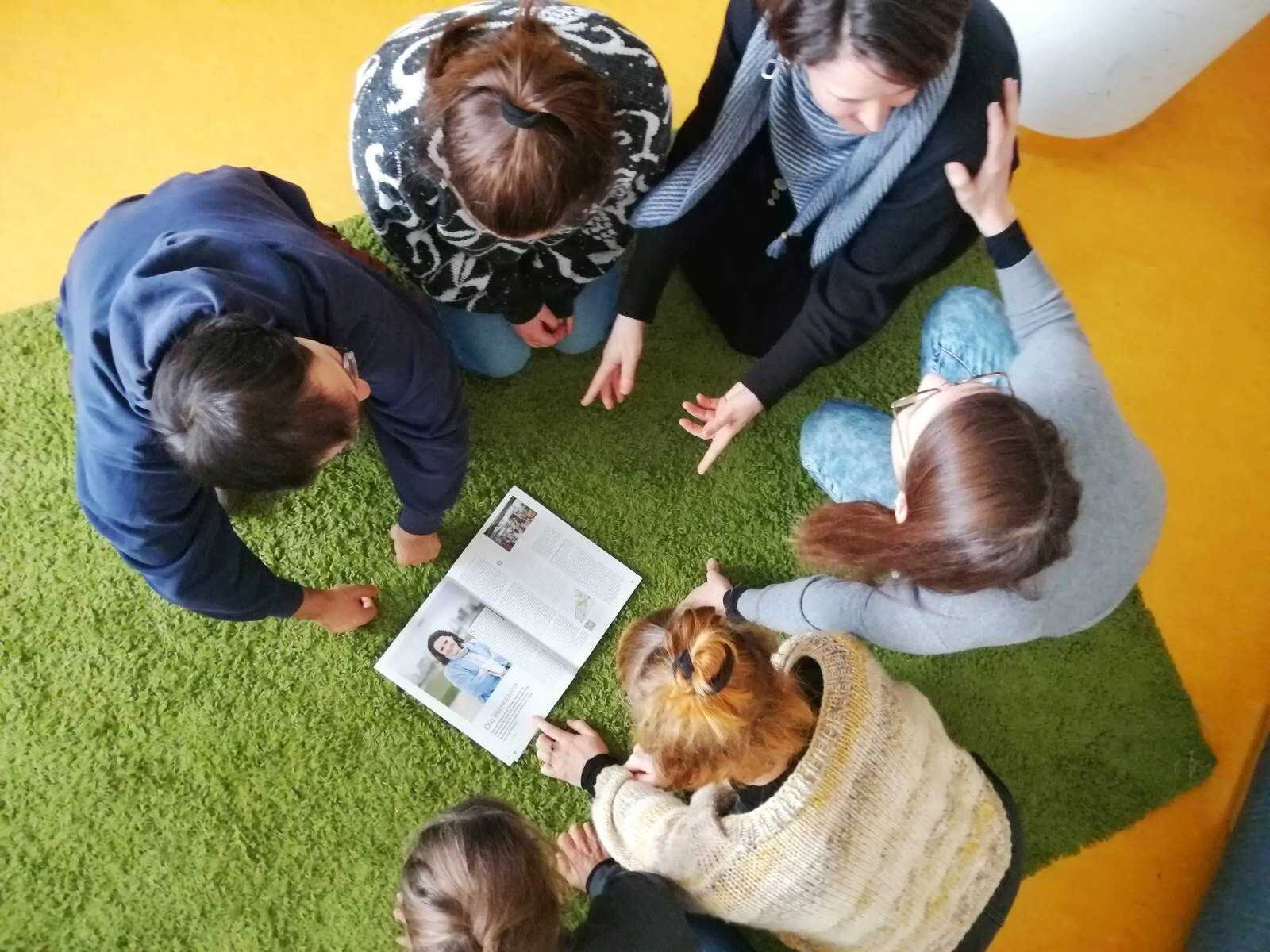 Das Team des Stadtteilmanagements schaut sich gemeinsam das workflow Heft an