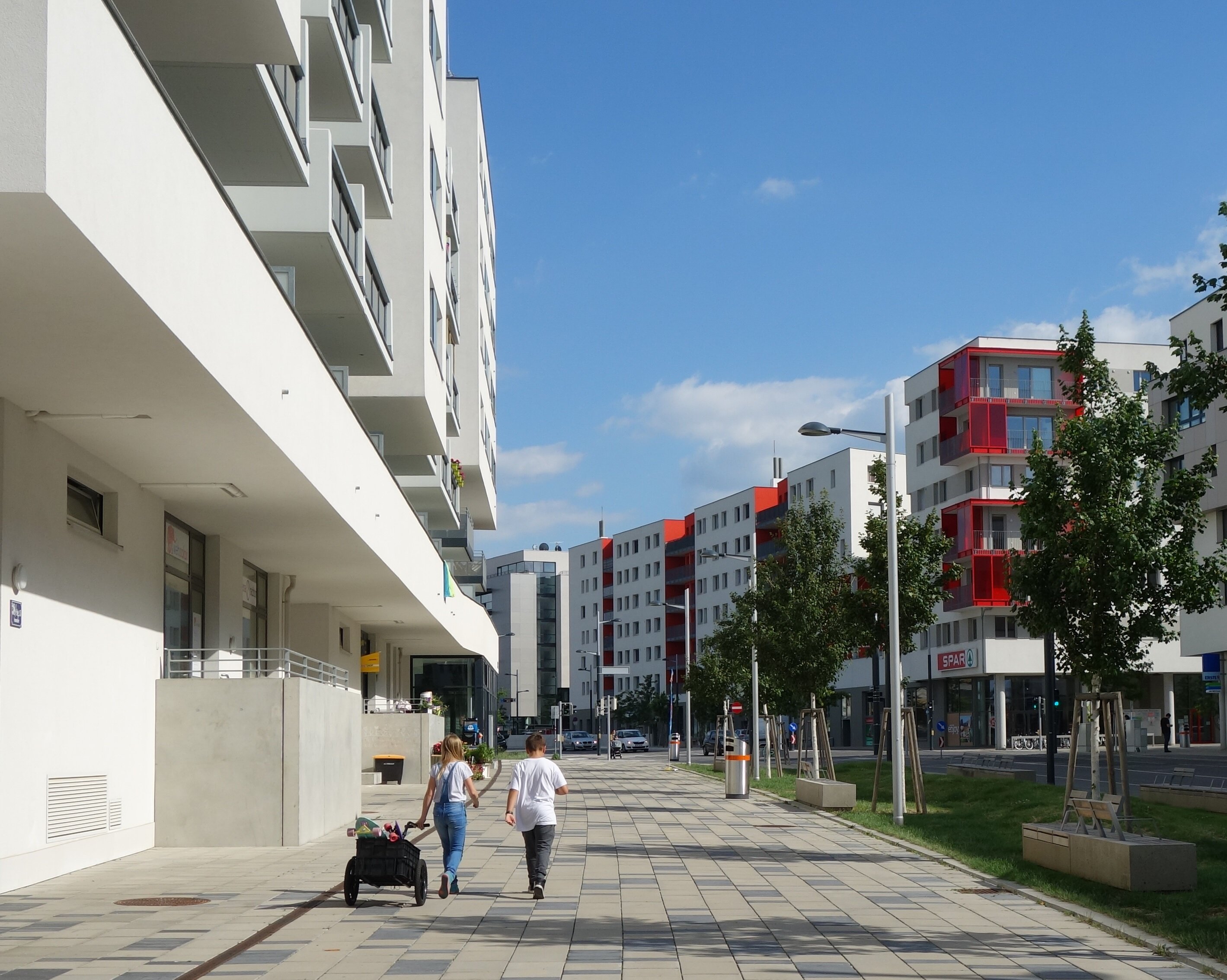 Kinder die auf einem Gehsteig spazieren