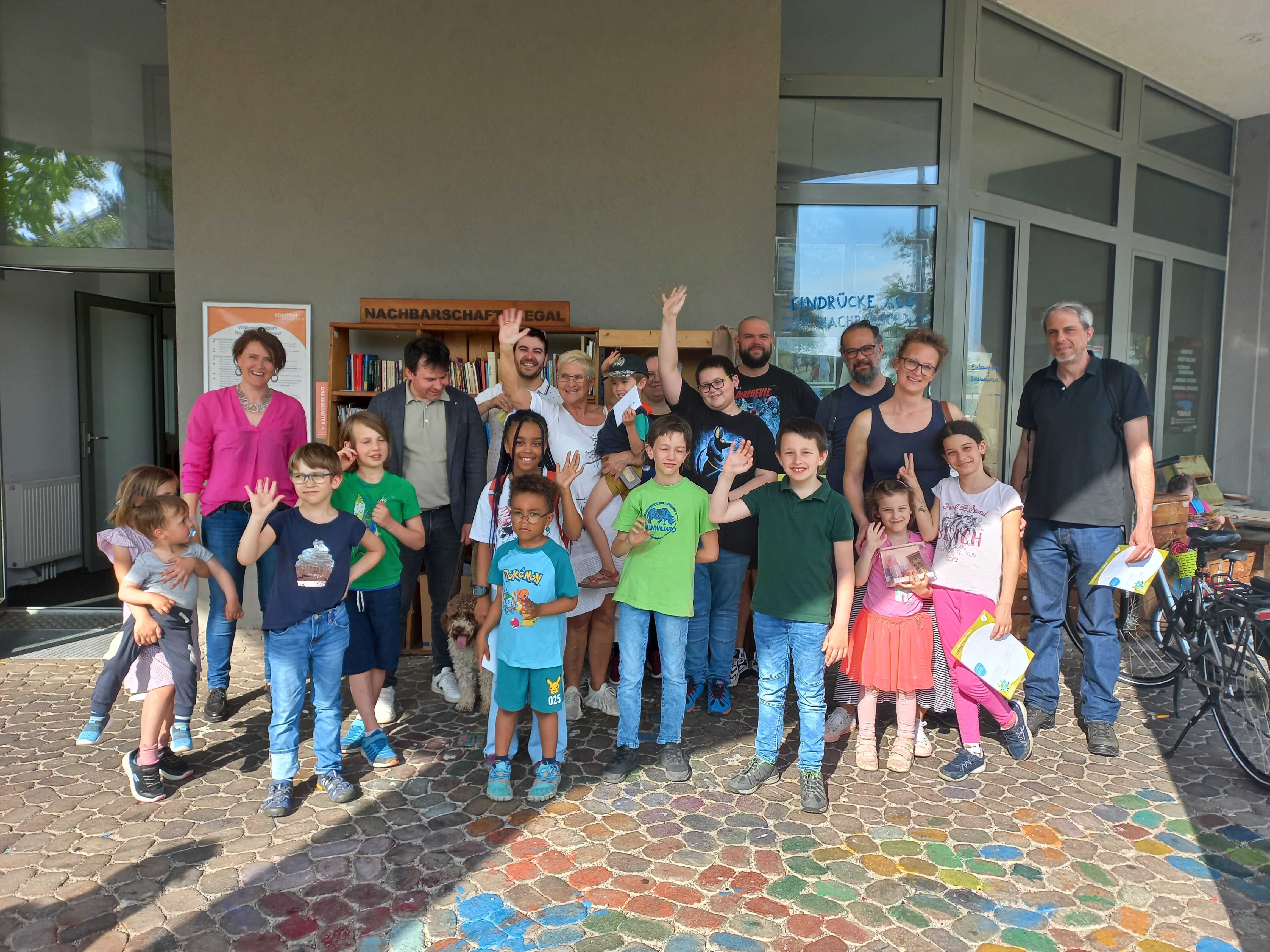 Die Gewinner*innen der Osterrätselralley bei der Preisverleihung vor dem Nachbarschaftsregal