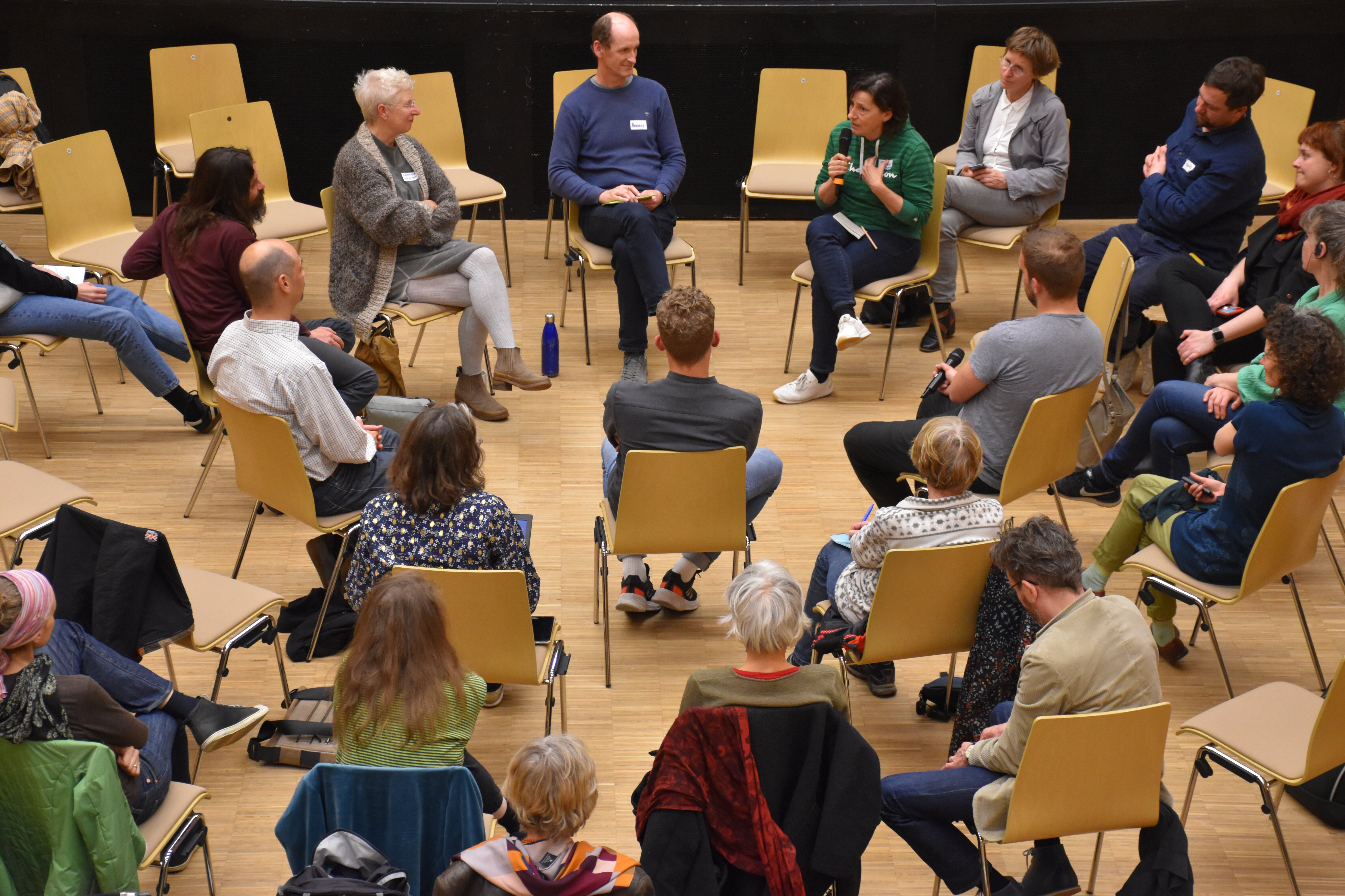 Menschen sitzen auf Sessel im Kreis
