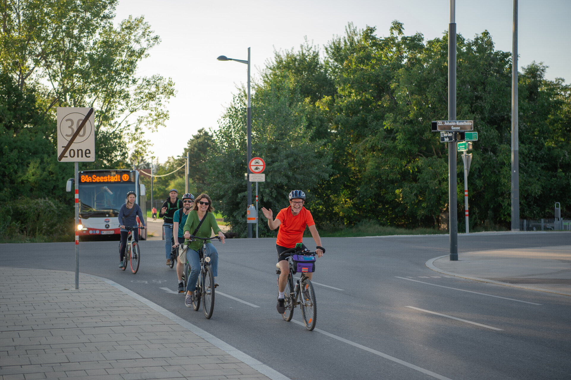 Menschen fahren auf Rädern, dahinter der Bus