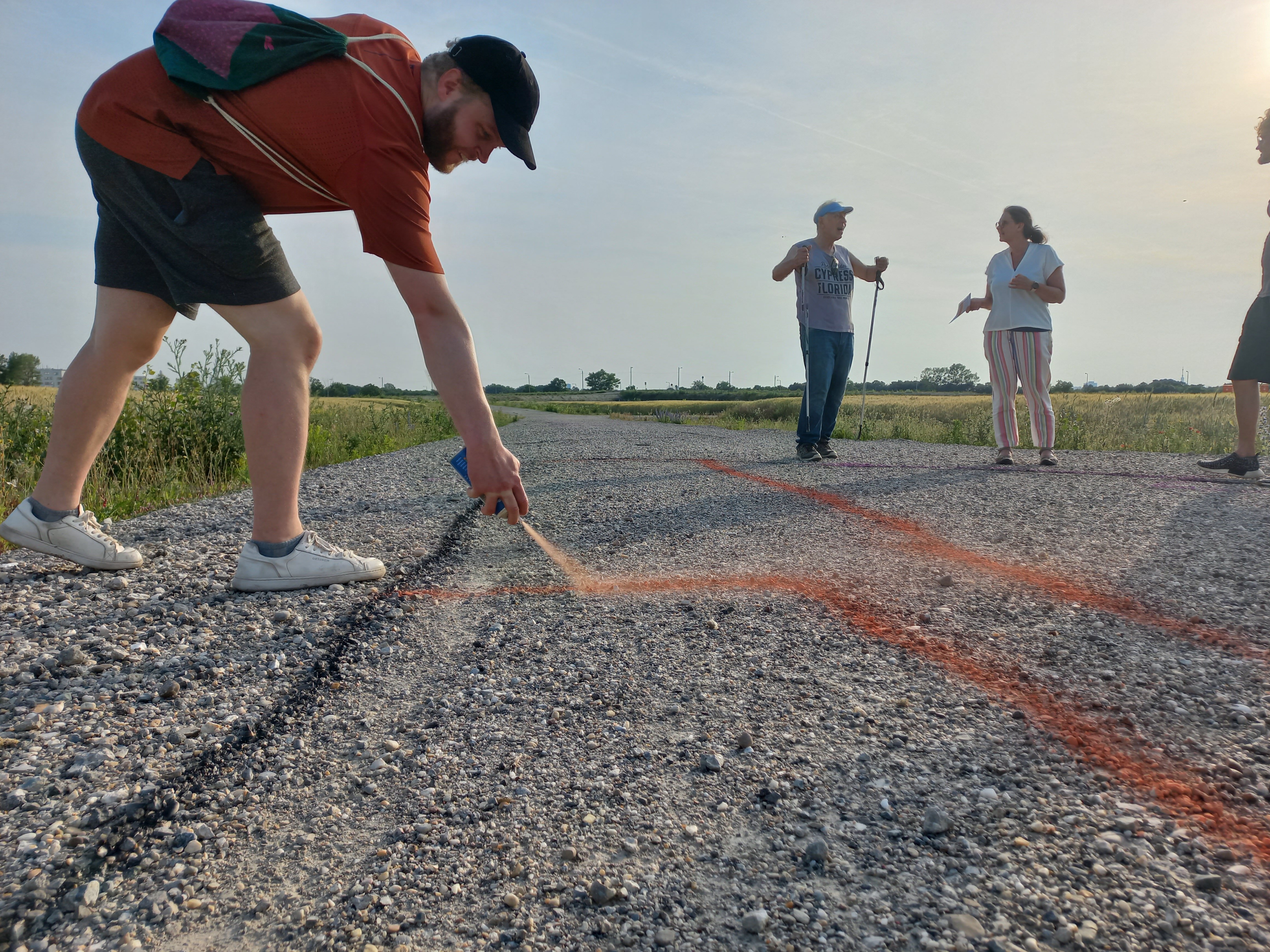 Ein Mann sprüht etwas auf Schotter