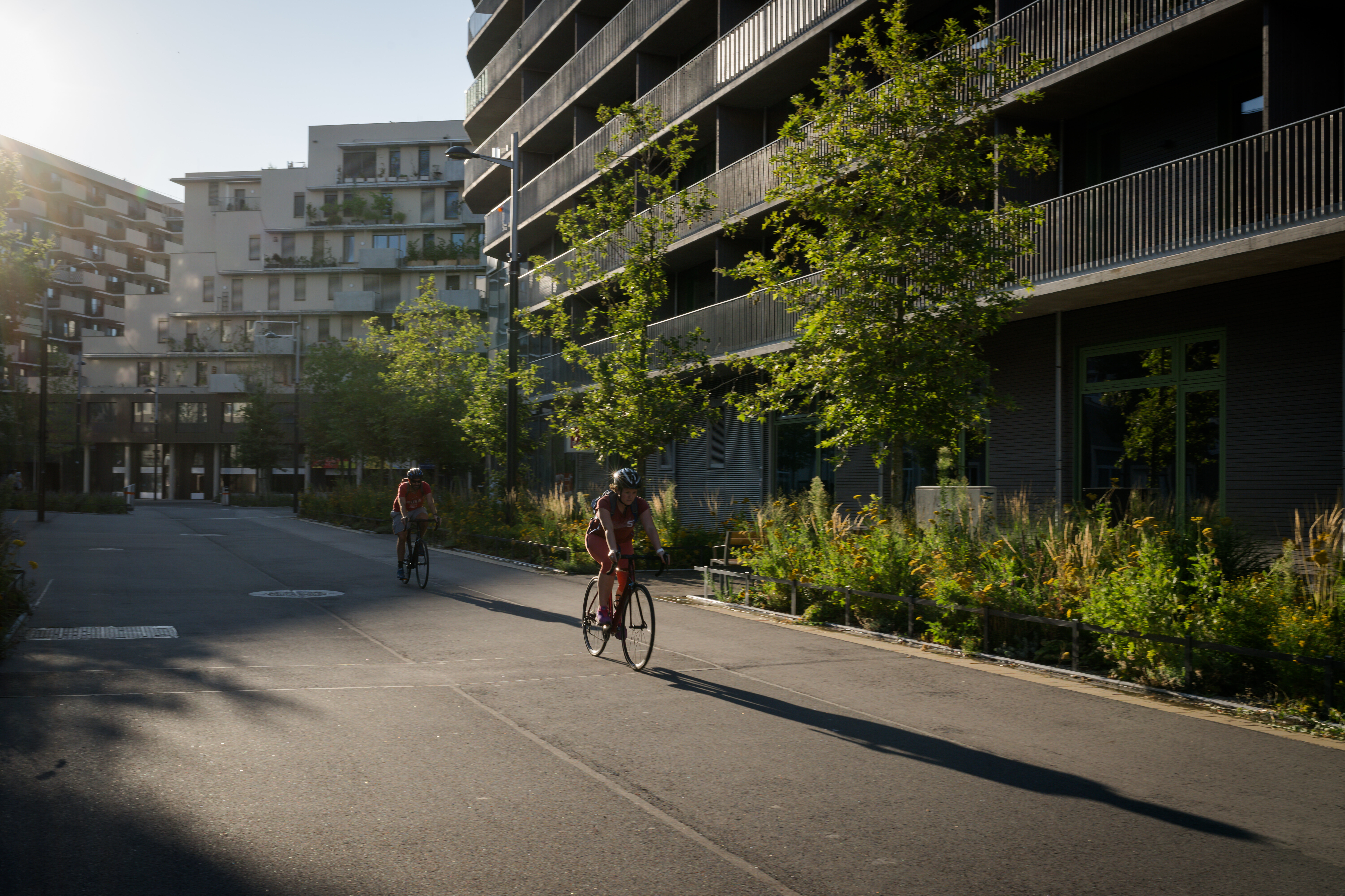 zwei Menschen fahren am Abend in der Seestadt durch die verkehrsberuhigte Zone