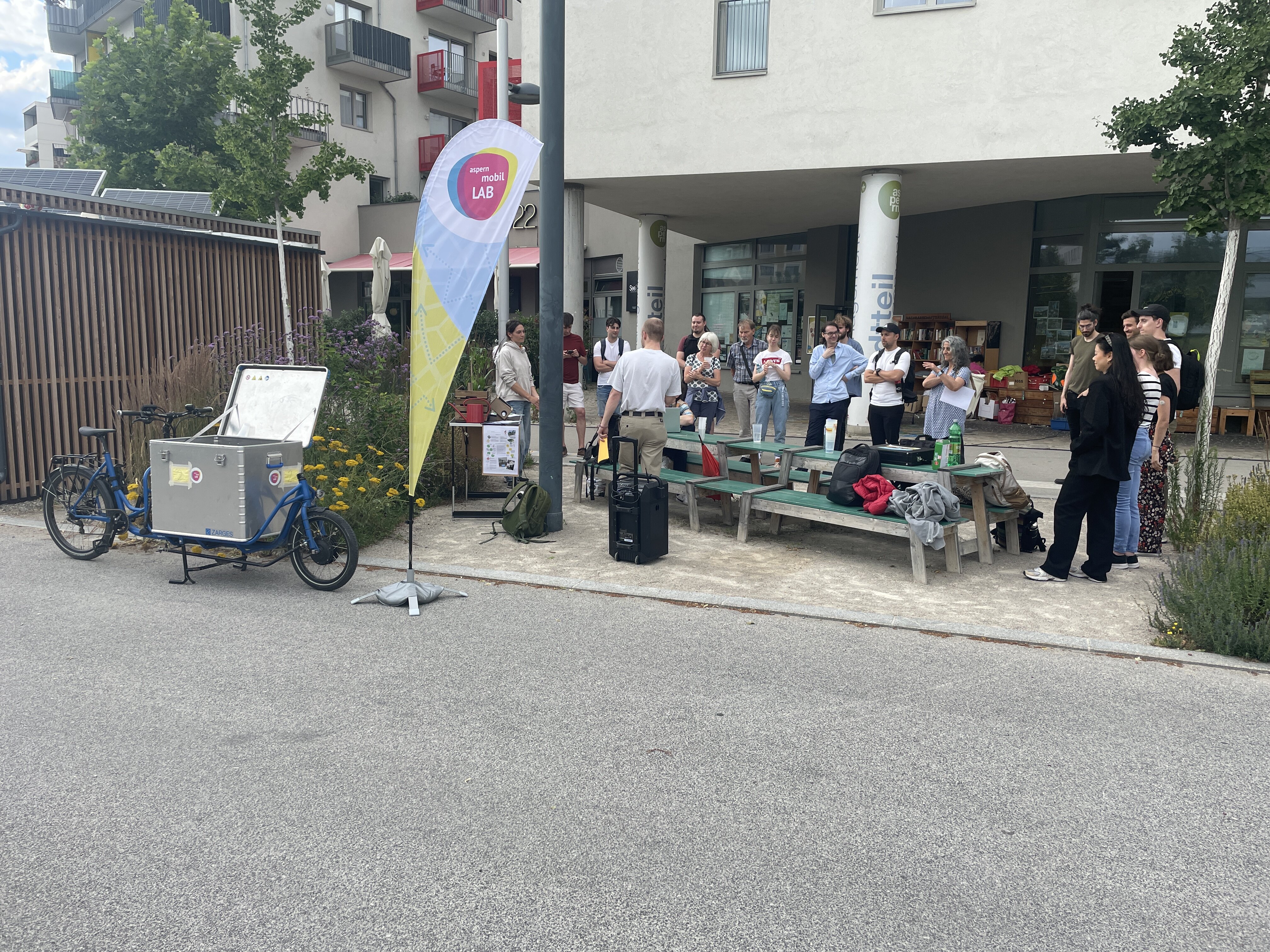 Das AML hat vor dem Büro des STM das Lastenrad und eine Fahne aufgebaut