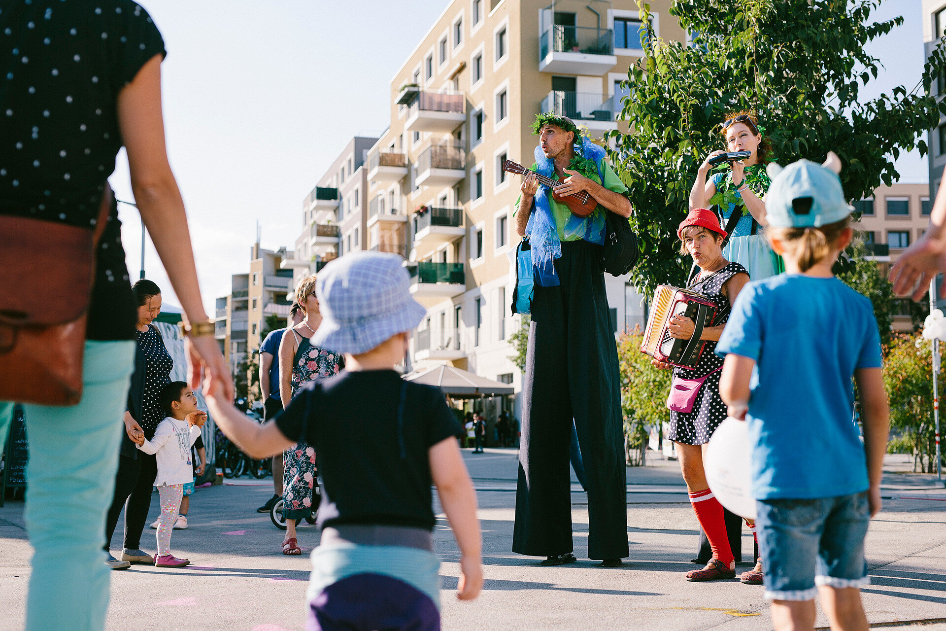 2 große Menschen und ein Clown spielt Akkordion 