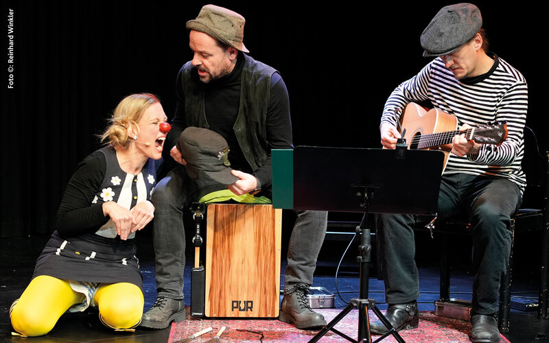 3 menschen auf der Bühne