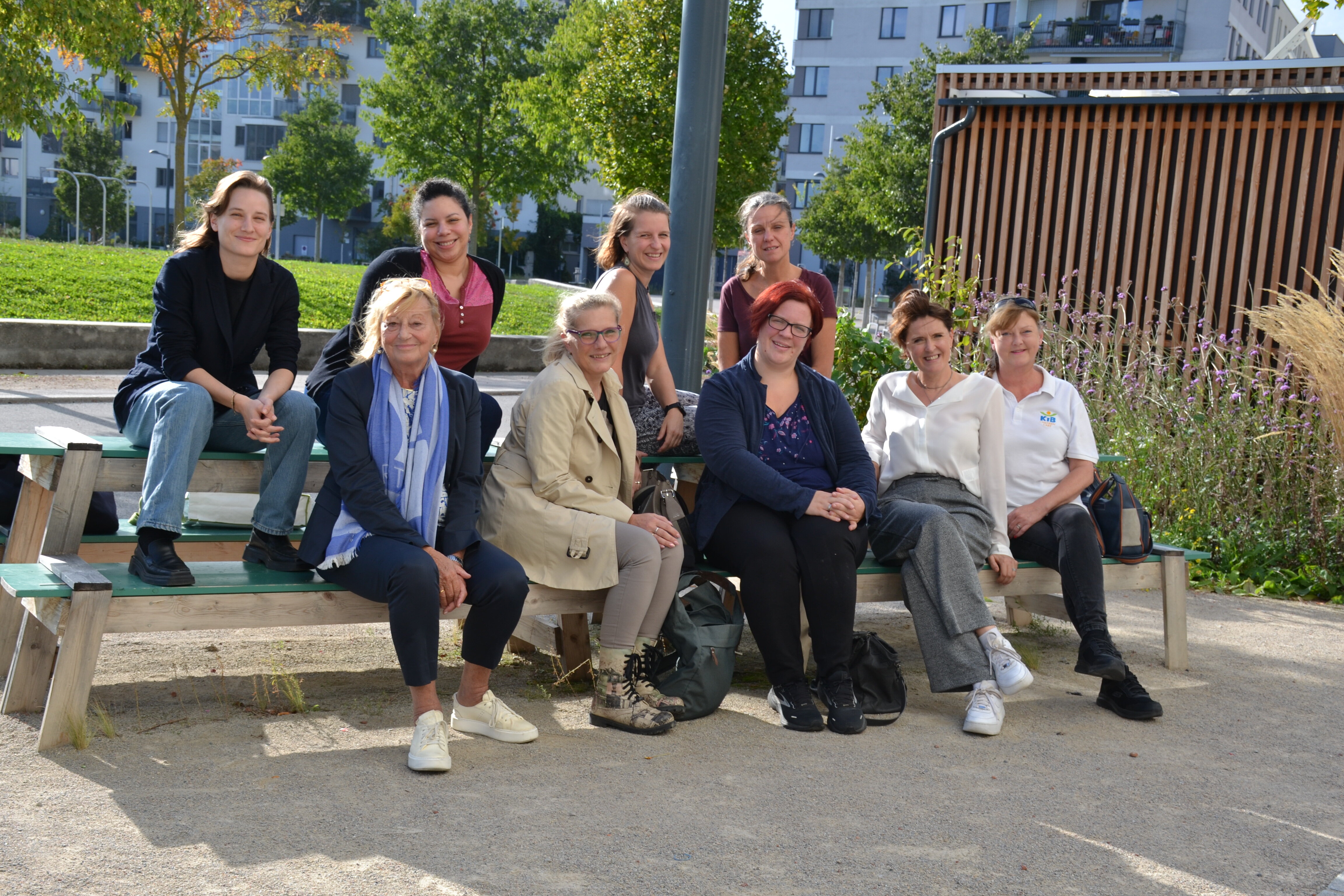 Menschen sitzen zusammen auf einer Picknickbank und lächeln