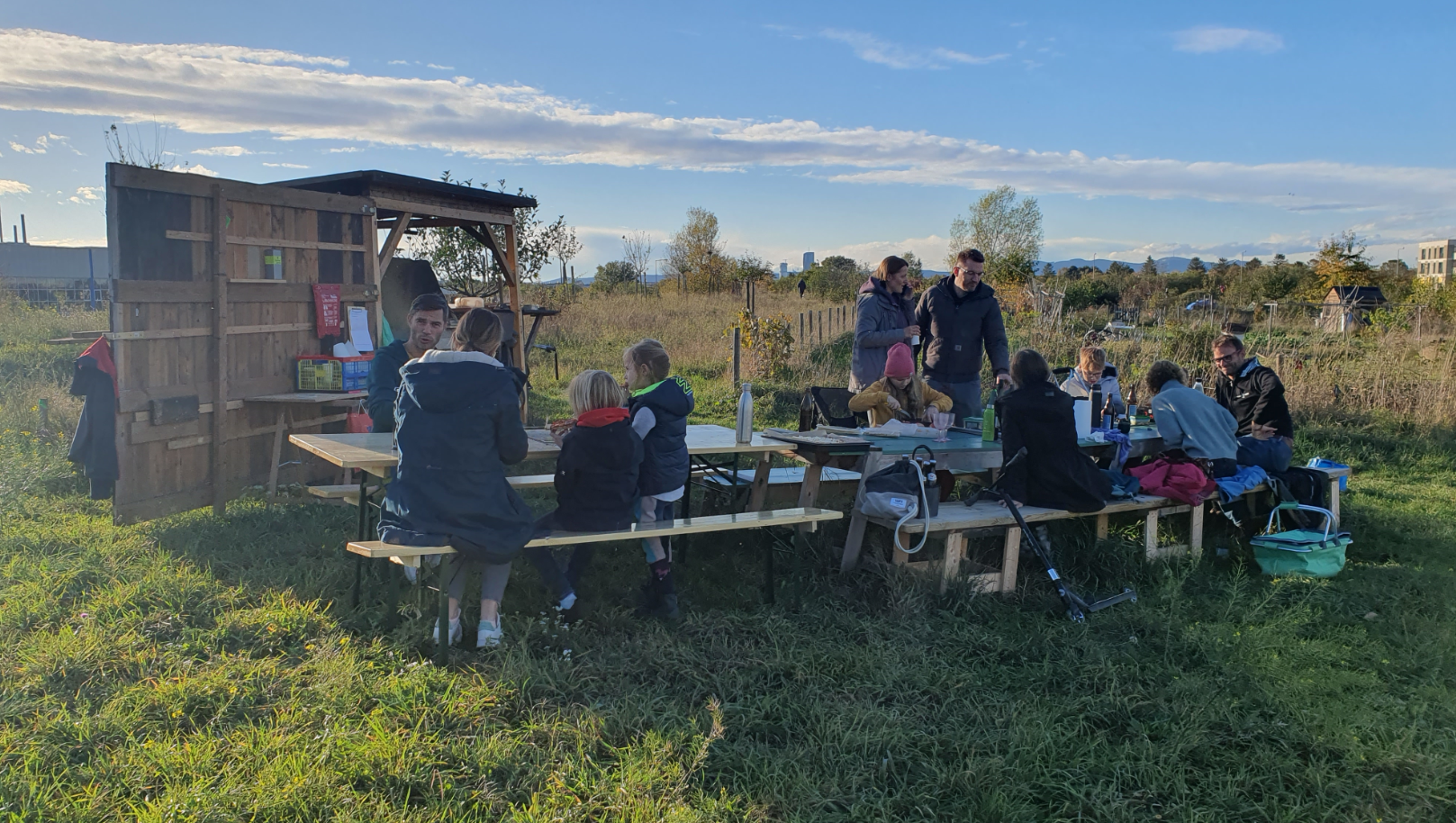 Menschen sitzen in der Wiese auf Bänken