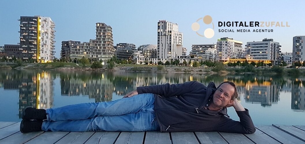 Mensch liegt am Steg, dahinter Wasser