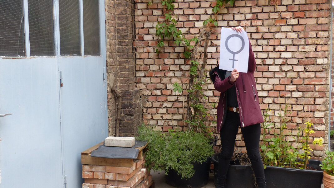 eine Frau die einen Zettel hoch hält