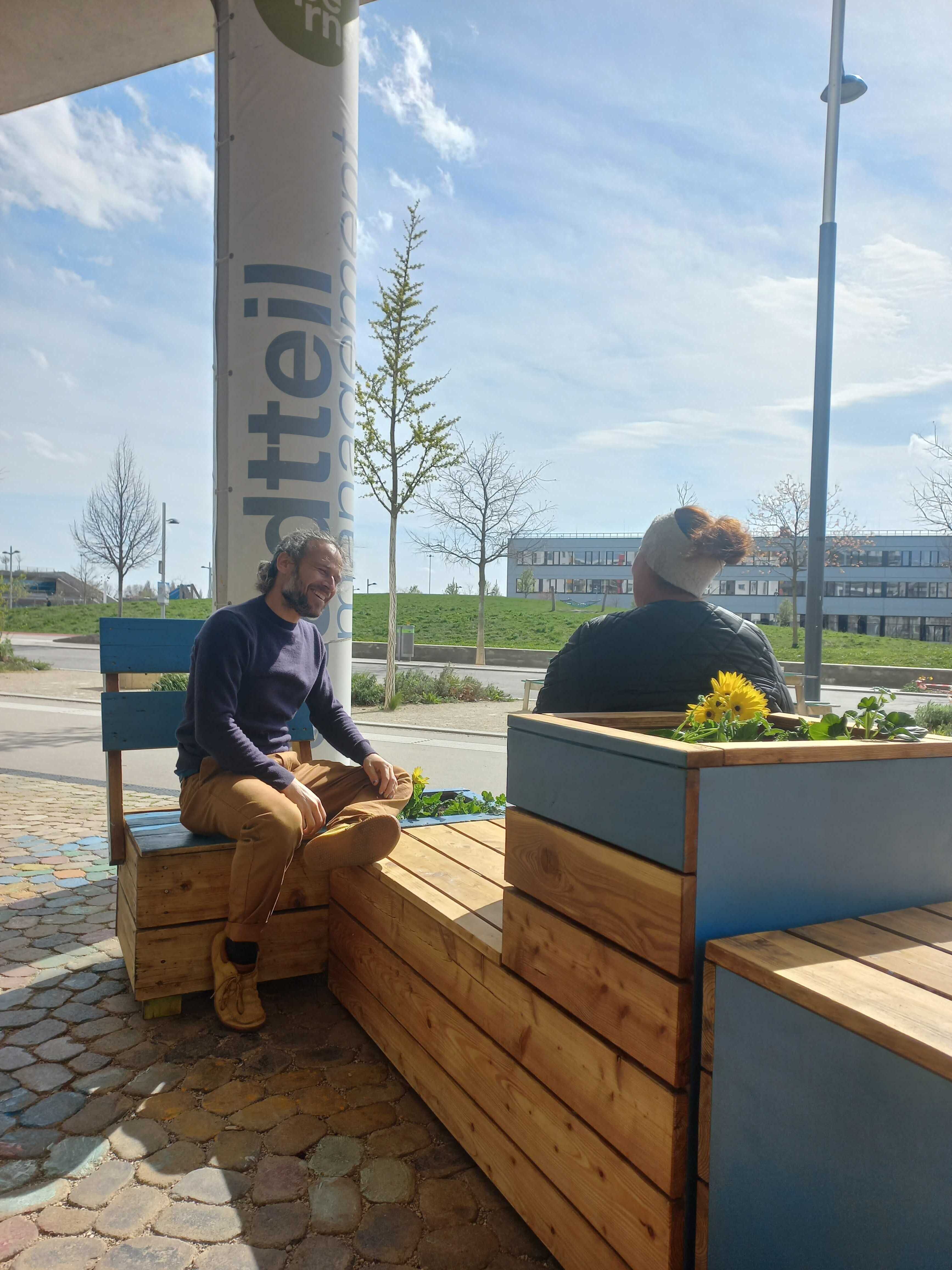 zwei Menschen sitzen auf einer Bank