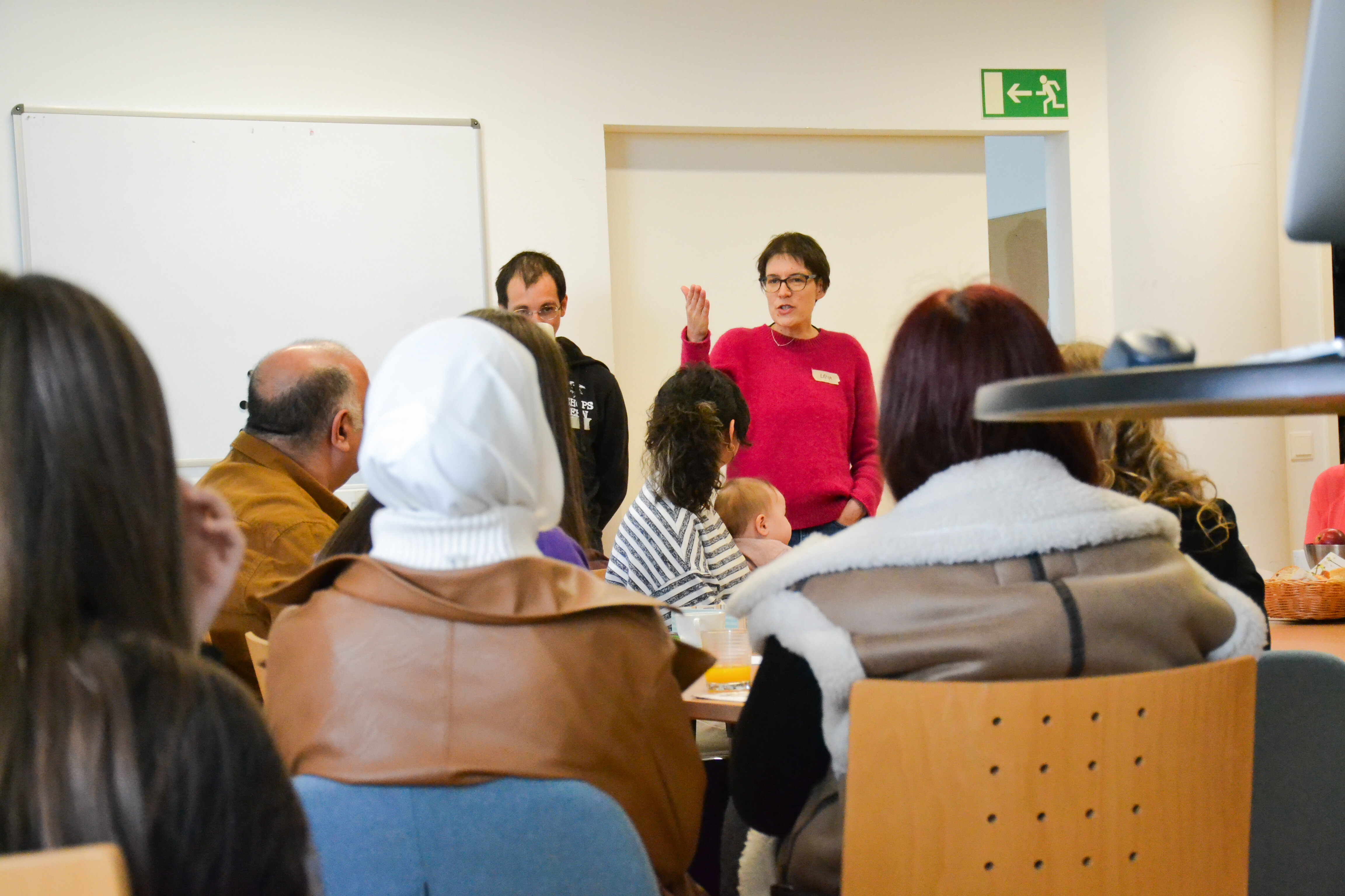 Menschen hören einer Frau beim Vortrag zu