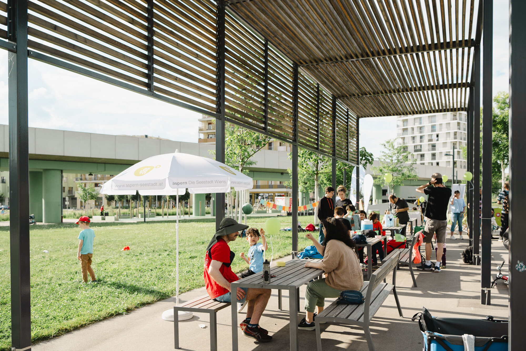Menschen sitzen im Park unter einer Veranda