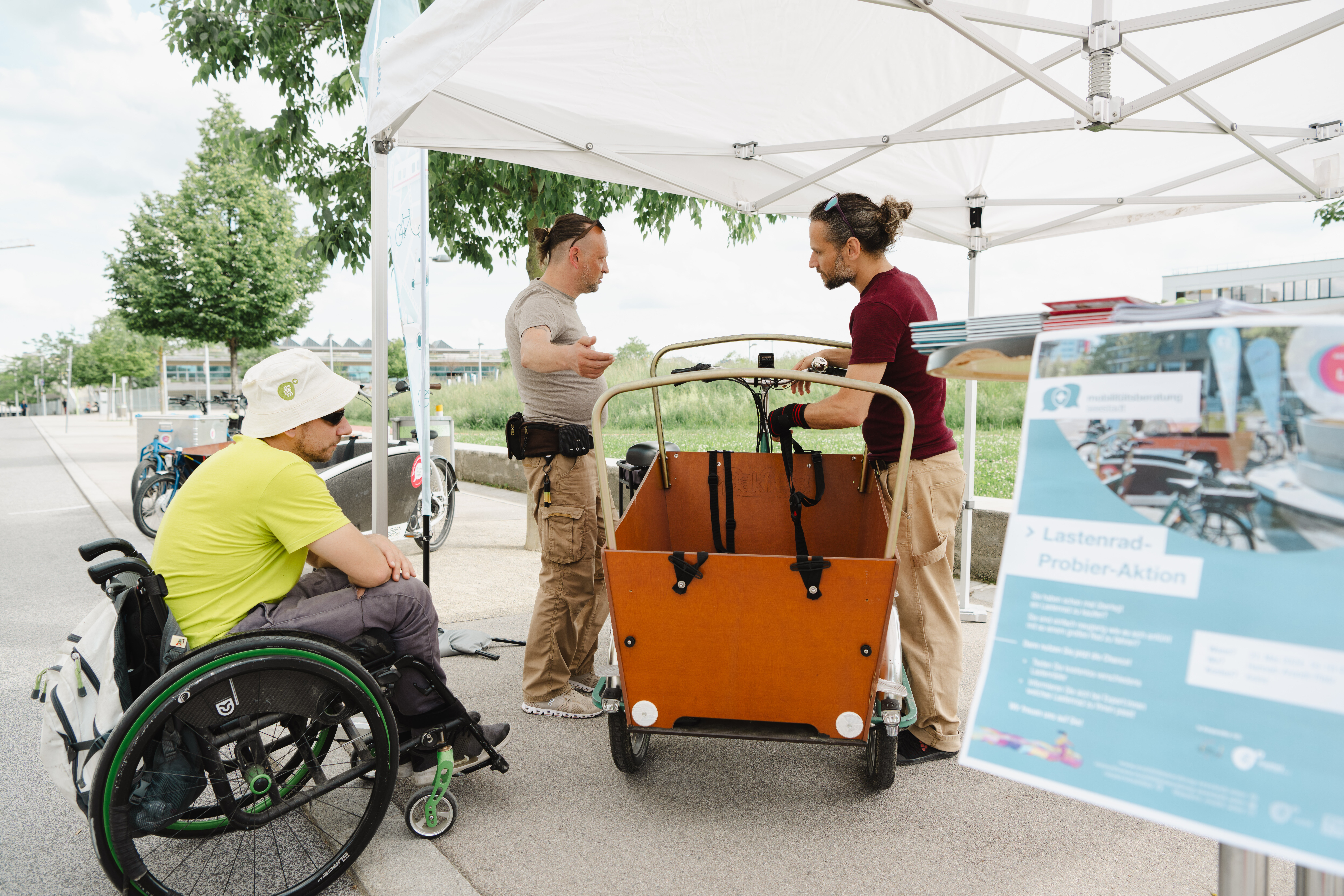 Menschen stehen um ein Lastenrad im Freien