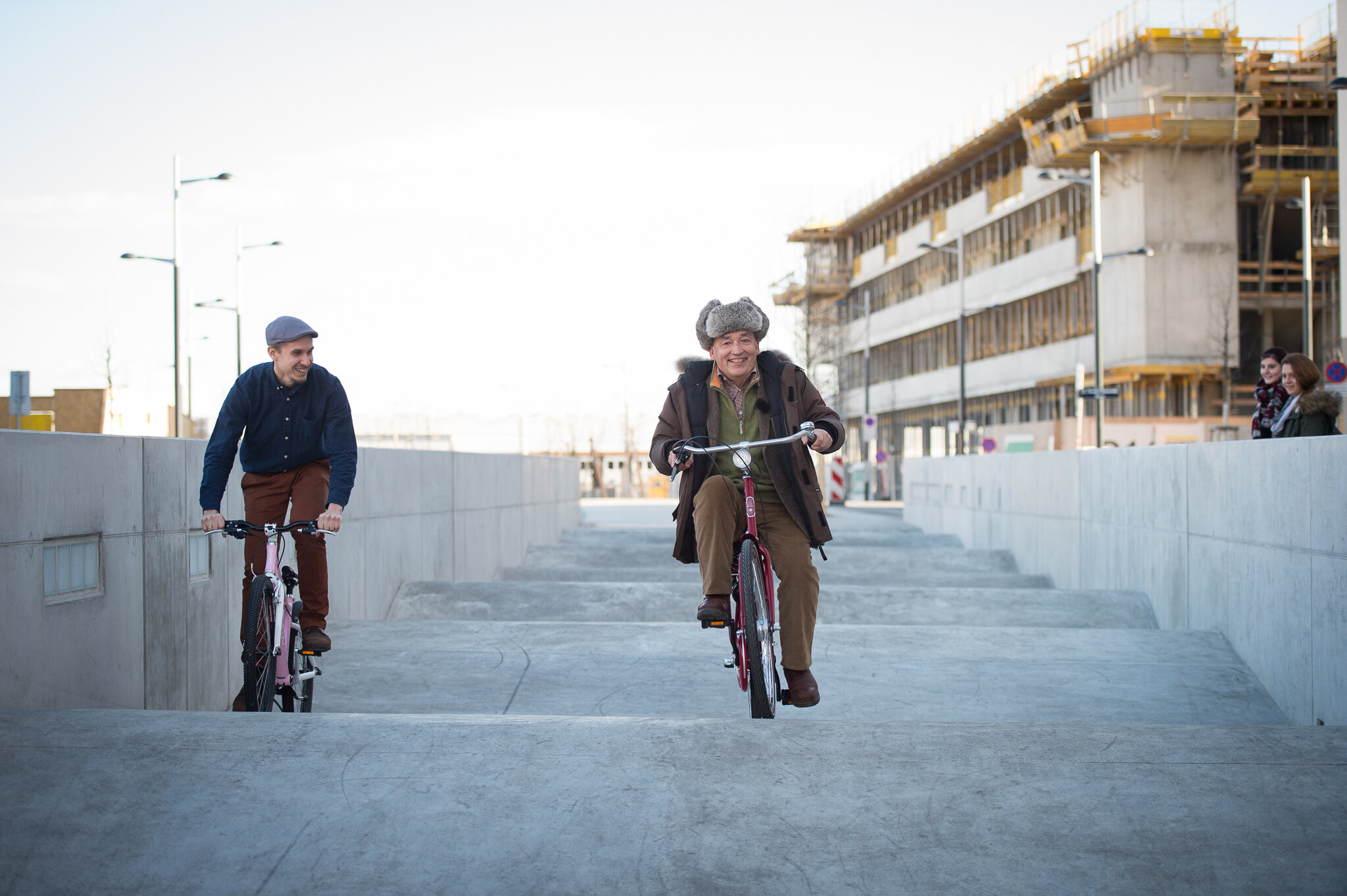 Glücksminsiter Dr. Tho fährt mit dem Fahhrad über über die Wellenbahn auf der Sonnenallee