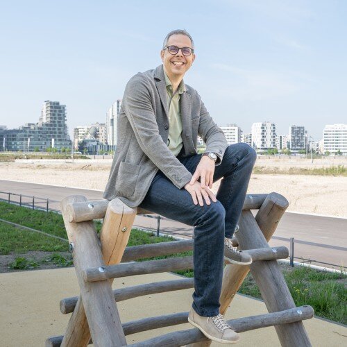 Peter Hinterkörner Peter Hinterkörner sitzend auf einem Spielgerät auf einem Spielplatz. Hinter ihm sind hohe Gebäude