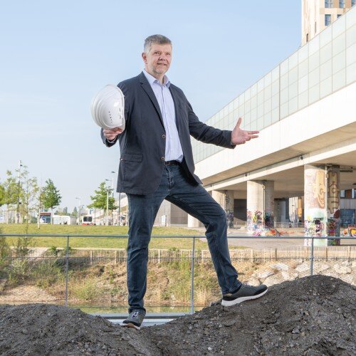 Robert Koselsky stehen mit einem Schutzhelm in der Hand.