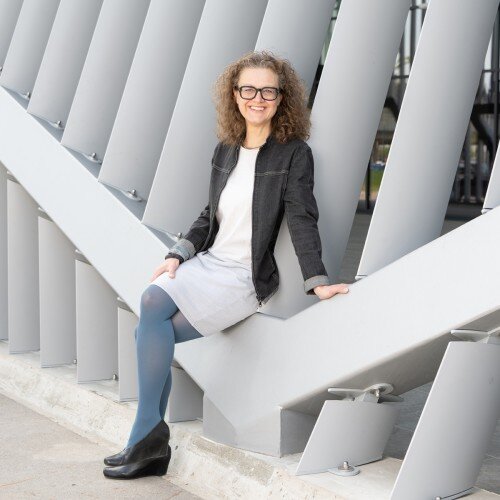 Ingrid Spörk Ingrid Spörk sitzend auf einem modernen Geländer
