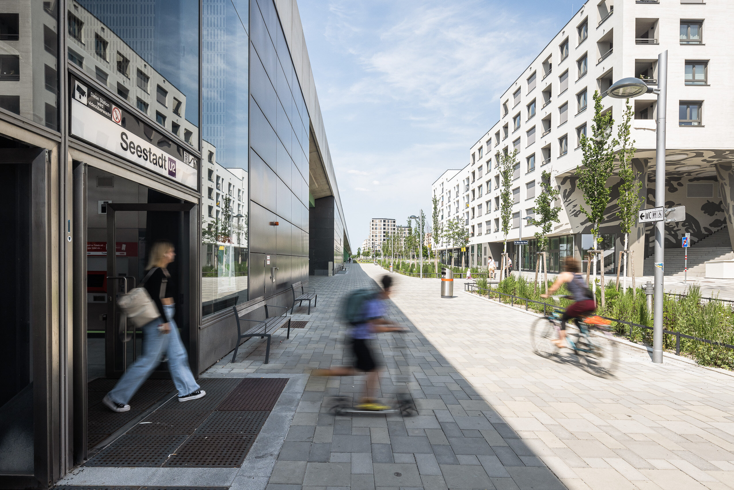 modernes Wohngebäude mit lebendiger Erdgeschoßzone direkt beim U-Bahn Ausgang