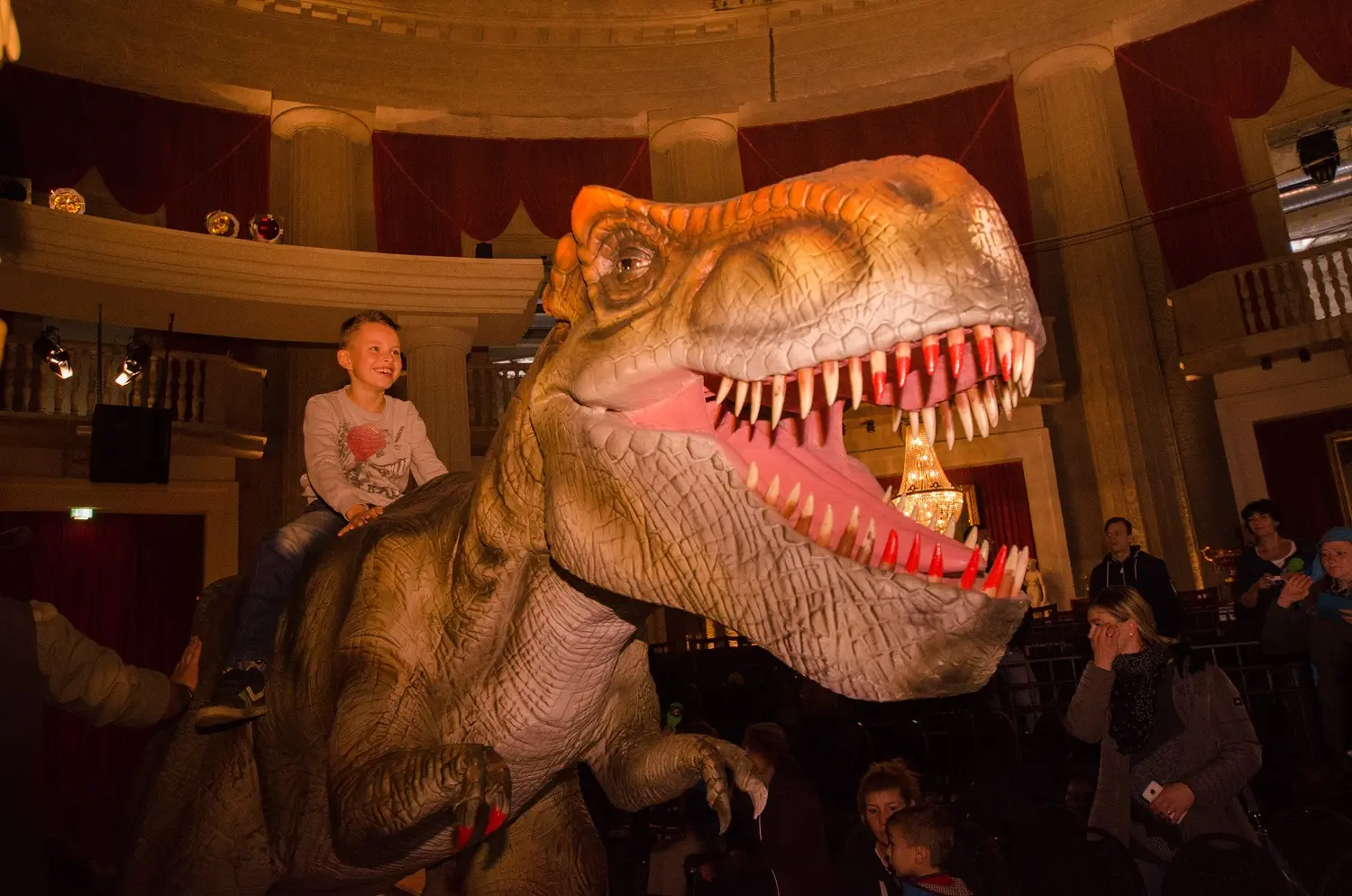 Junge sitzt auf dem Rücken eines riesigen animierten Dinosauriers