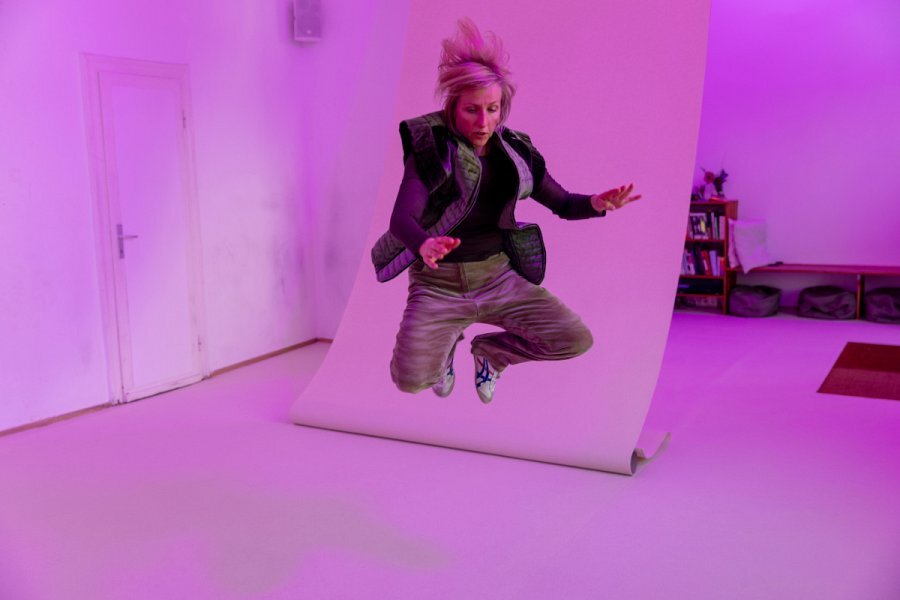 eine Frau springt in die Luft, das Bild ist rosa eingefärbt