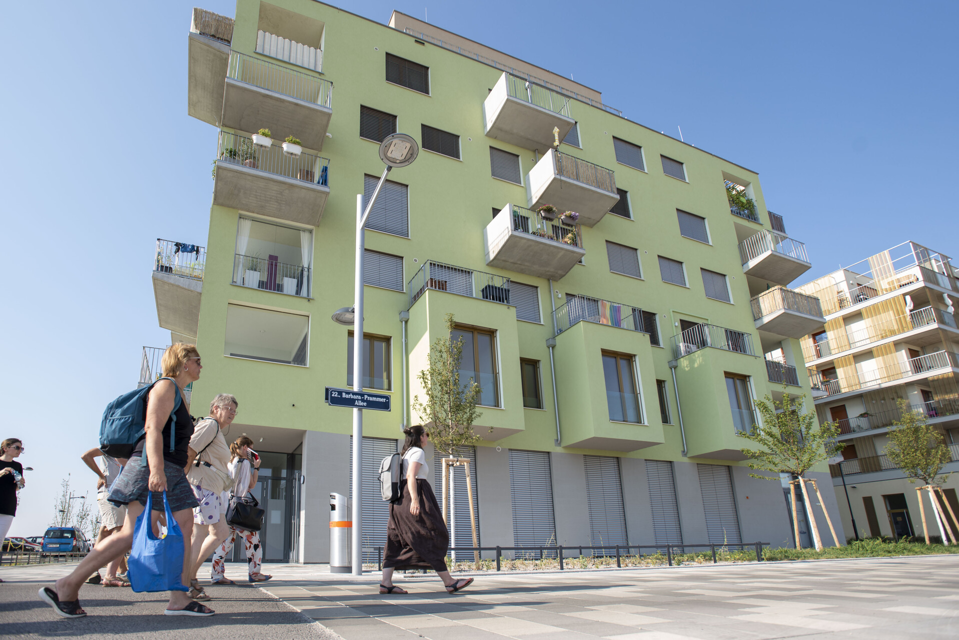 Gruppe spaziert auf einer Straße, Haus im Hintergrund