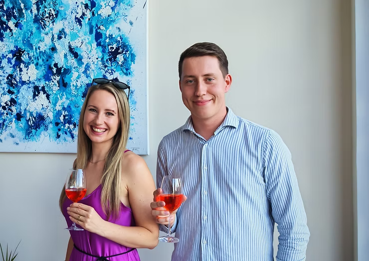 Foto von Künstlerin Farkas mit CEO von Studio Hnat Wolfang, sie halten ein Glas Aperol in der Hand und lächeln in die Kamera
