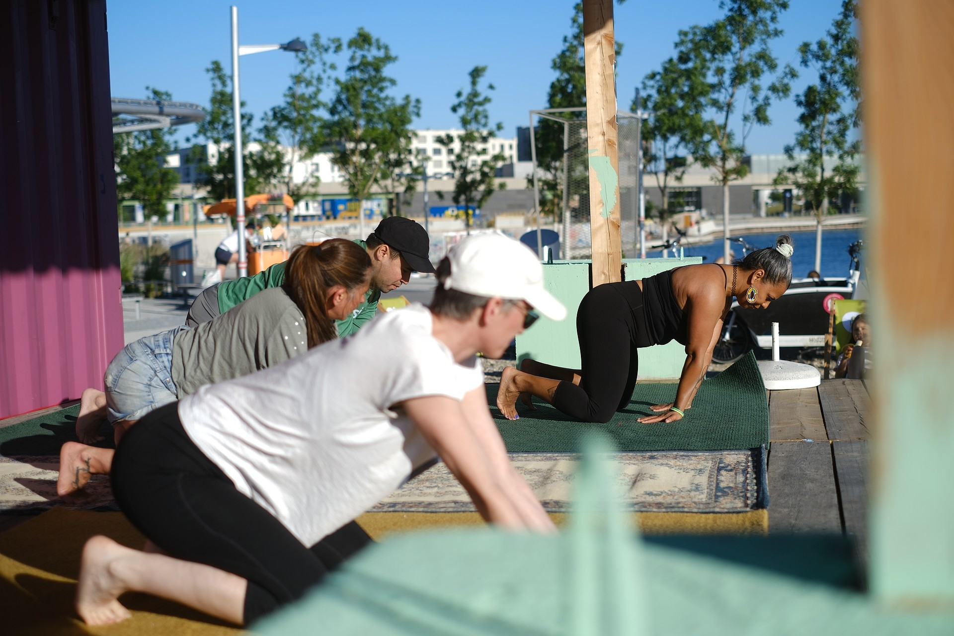 Menschen trainieren Animal Flow auf einer Outdoor-Bühne an einem See