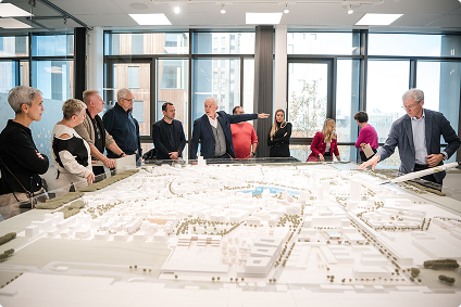 Mehrere Personen stehen vor einem großen Architekturmodell.