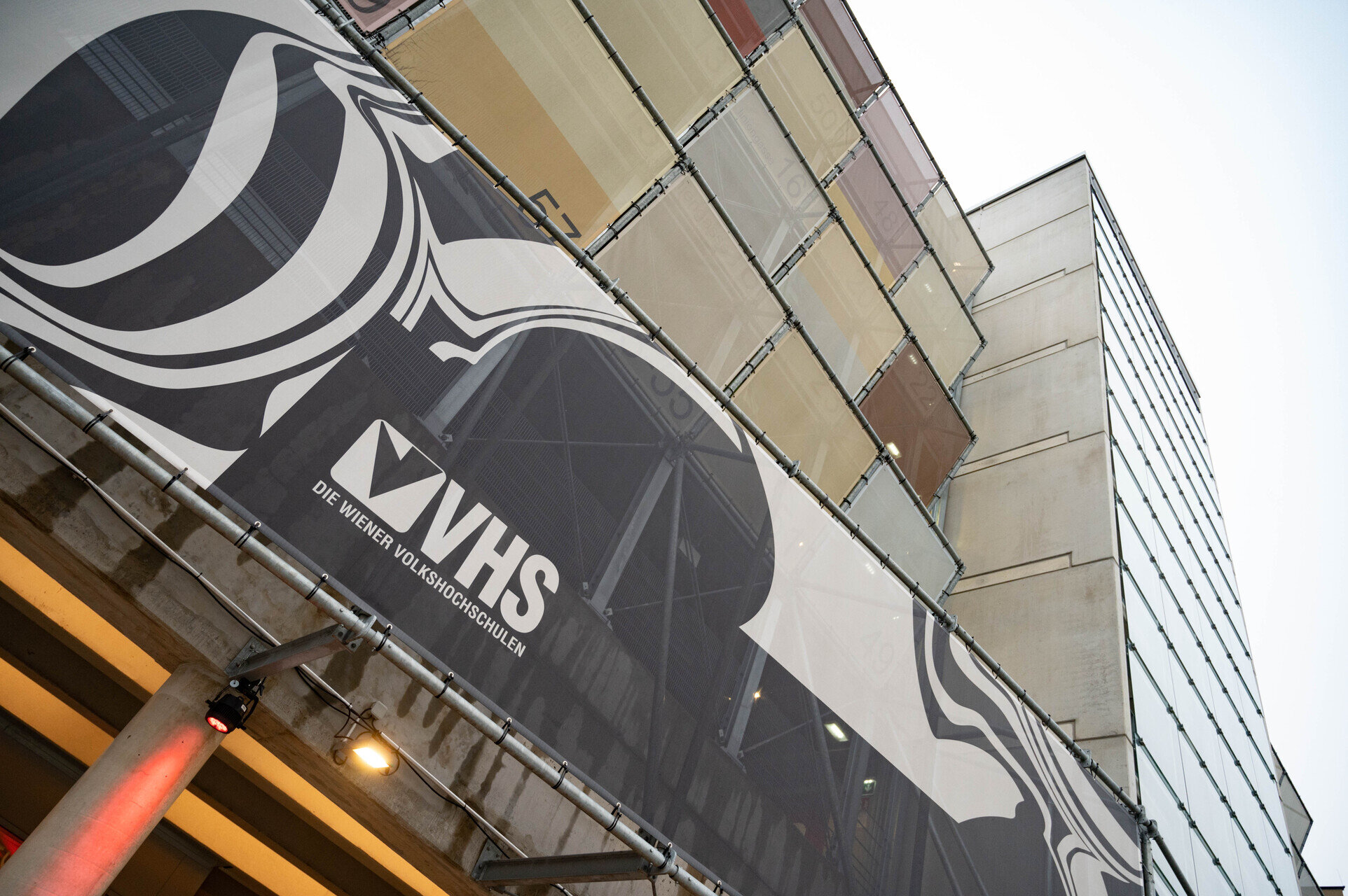 Hochhaus mit schwarz-weißem Schriftzugbanner.