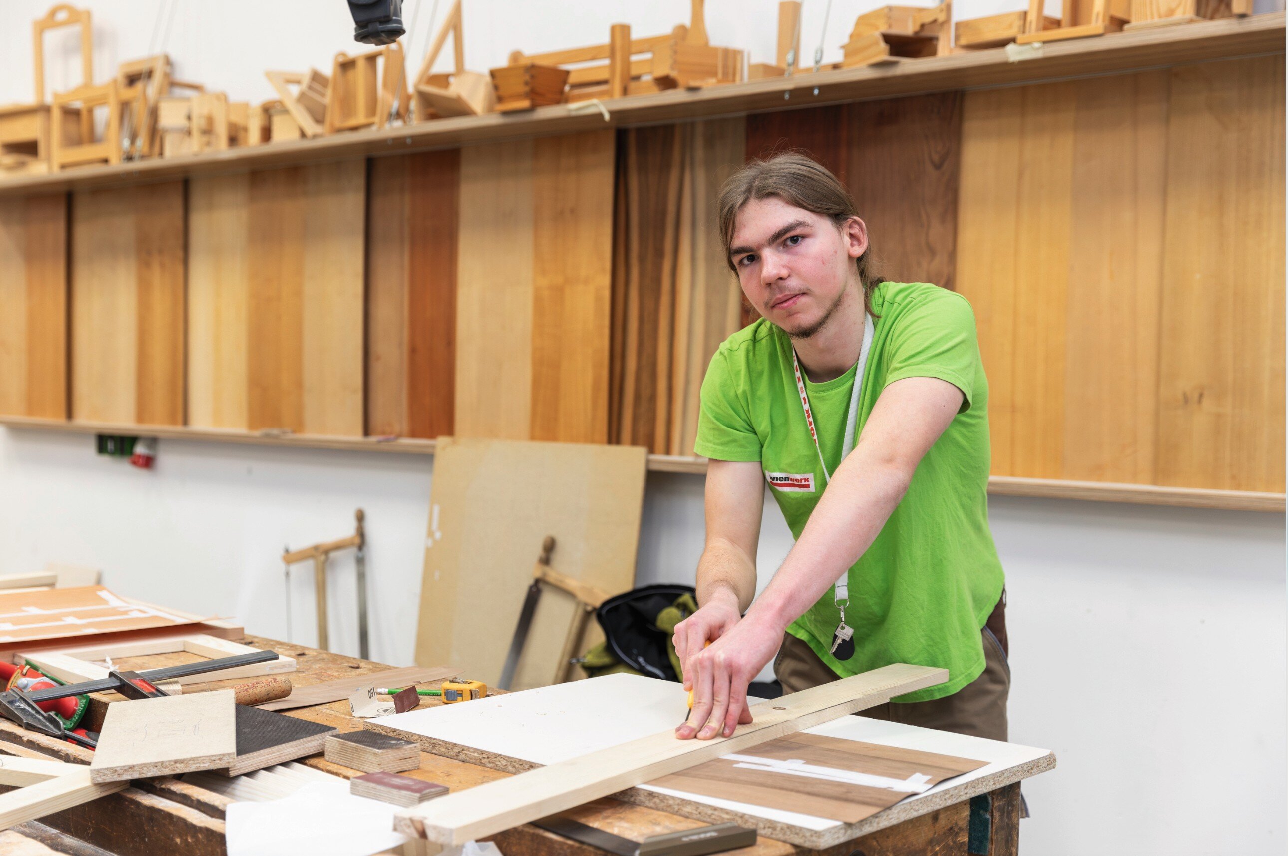 Junger Mann, der gerade an eine Holzplatte arbeitet.