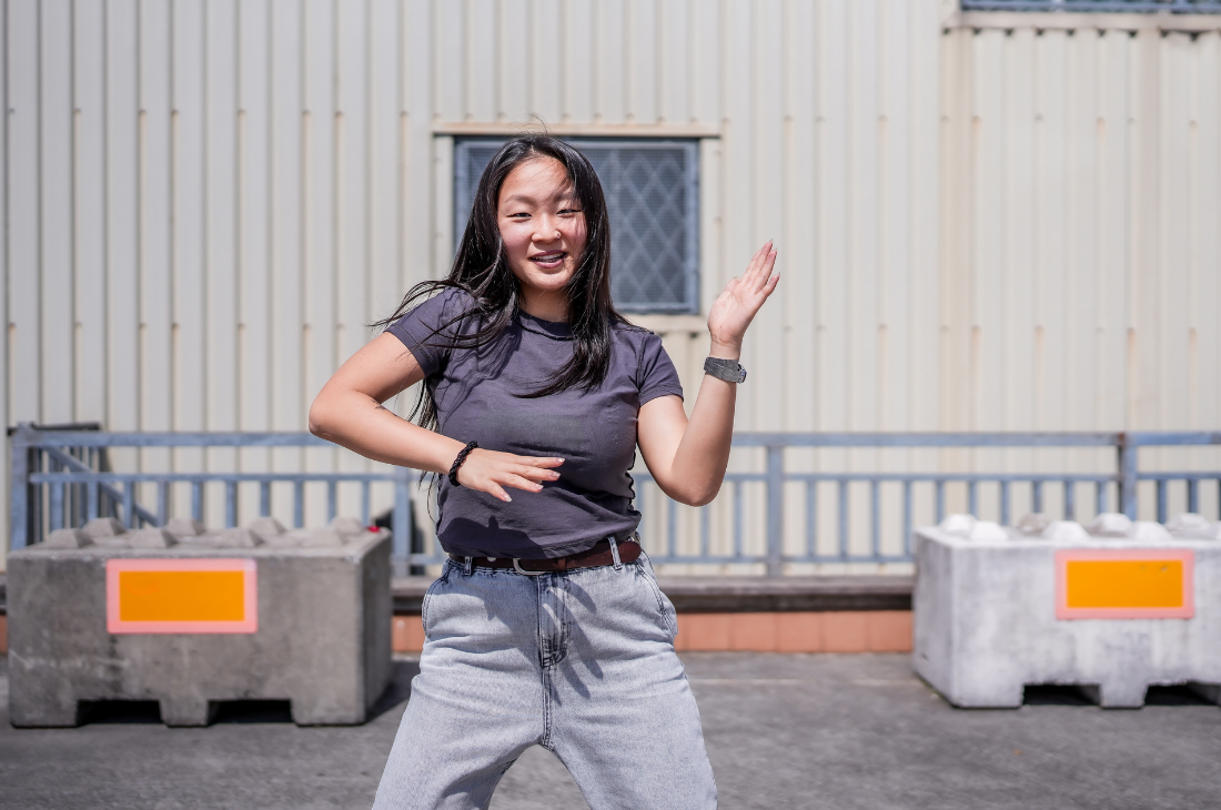 Asiatisch-stämmiges Mädchen tanzt in Jeans und T-Shirt
