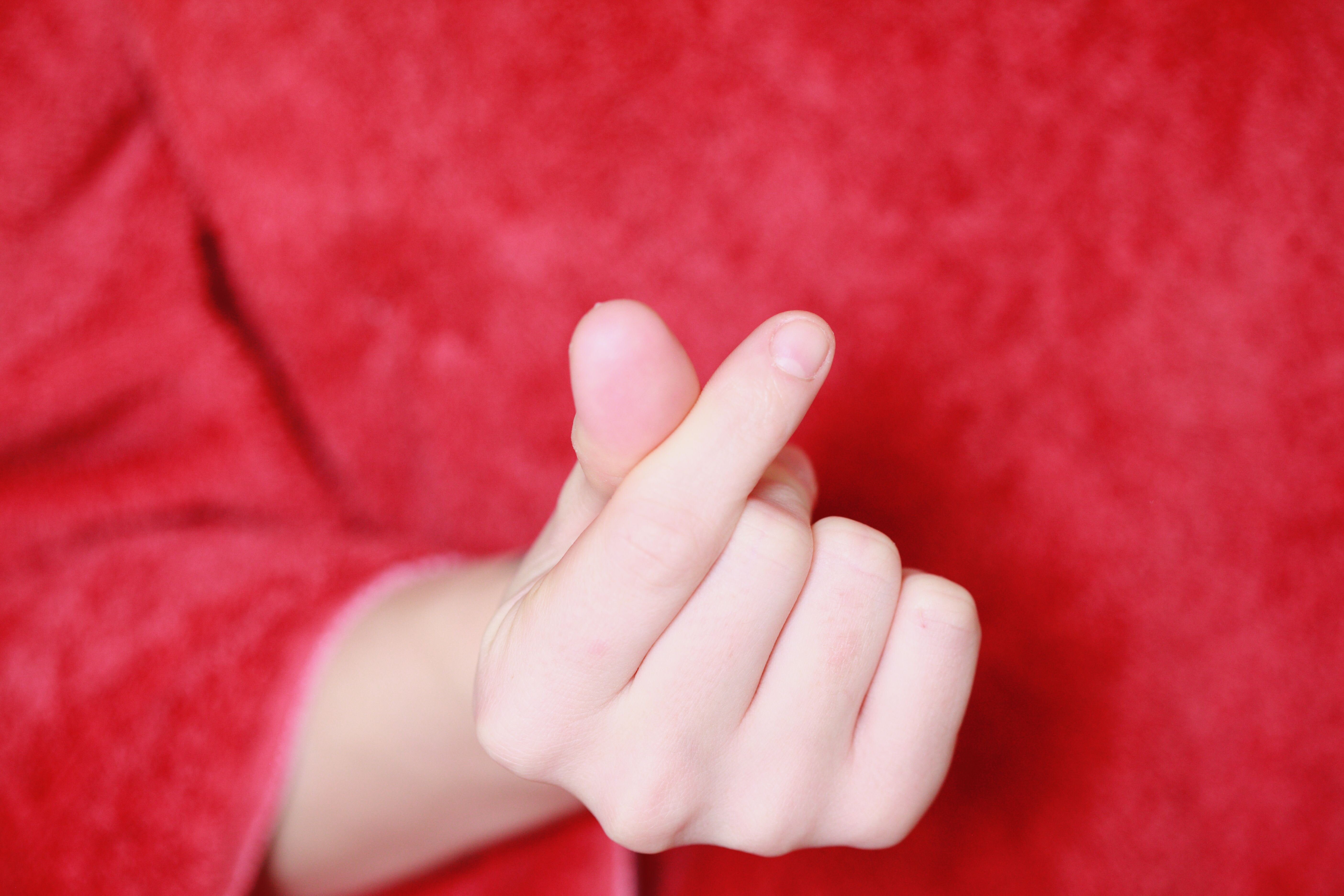 Mädchen, das mit den Fingern ein Herz formt