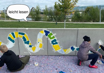Kinder malen auf einer Mauer