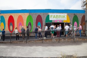 Veranstaltungsgäste vor beamalter Location "FABRIK" in aspern Seestadt