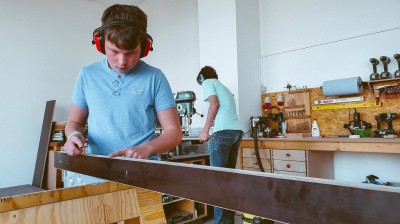 Menschen arbeiten in einer Holzwerkstatt an Möbel.