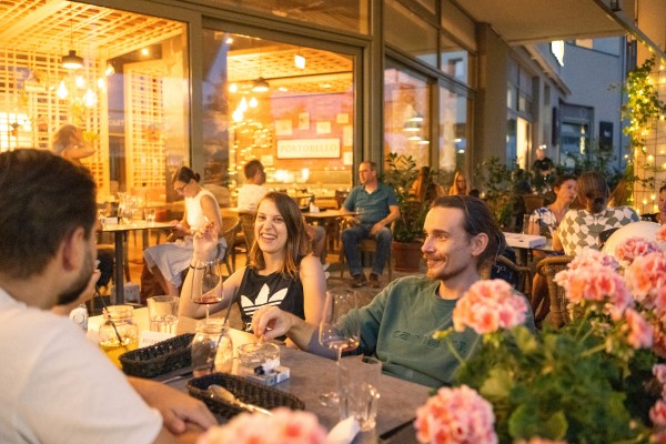 Eine Gruppe sitzt am Tisch eines italienischen Restaurants beim Abendessen