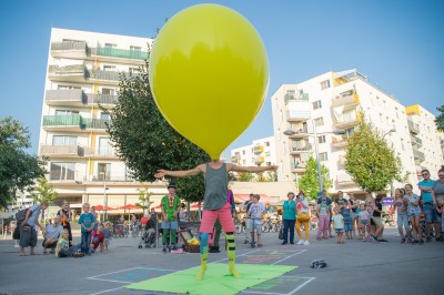 Ein Straßenspektakel, ein Künstler mit einem großen Luftballon und Zuschauern