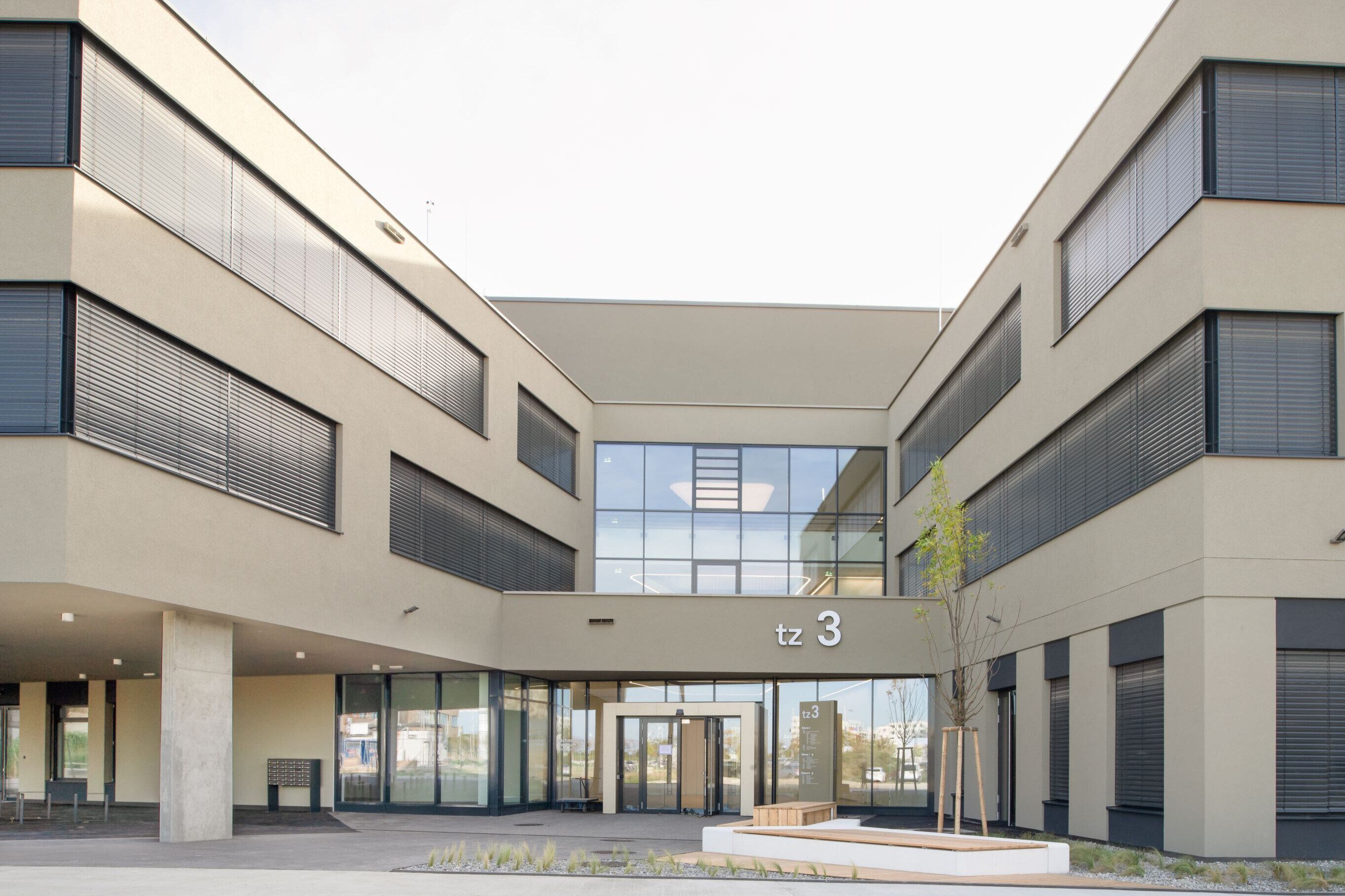 Gebäude, über dem Eingang steht tz3, davor ist ein junger Baum